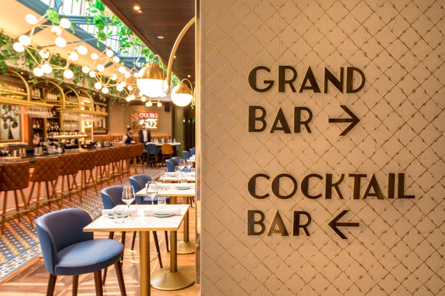 A photo of a sign in Café en Seine showing the way to the Grand Bar & Cocktail Bar